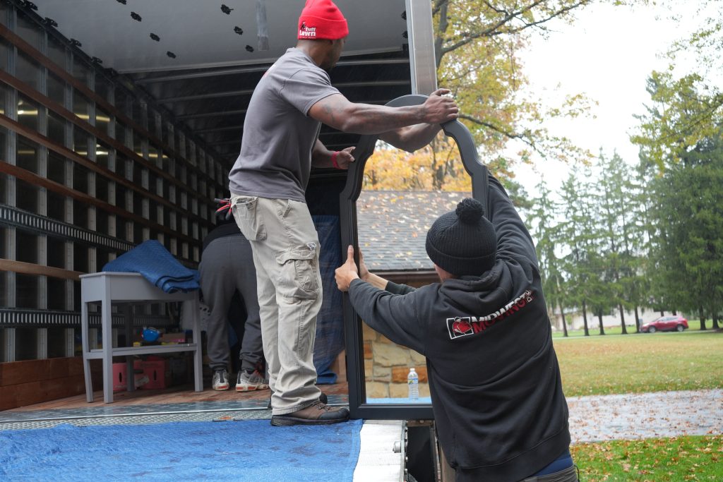 Two men moving furniture from truck